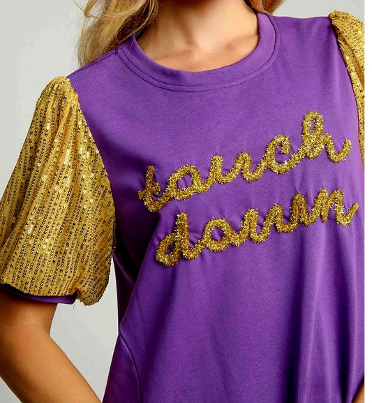 Purple dress with gold sequin sleeves and 'touchdown' in gold metallic text on a plain background