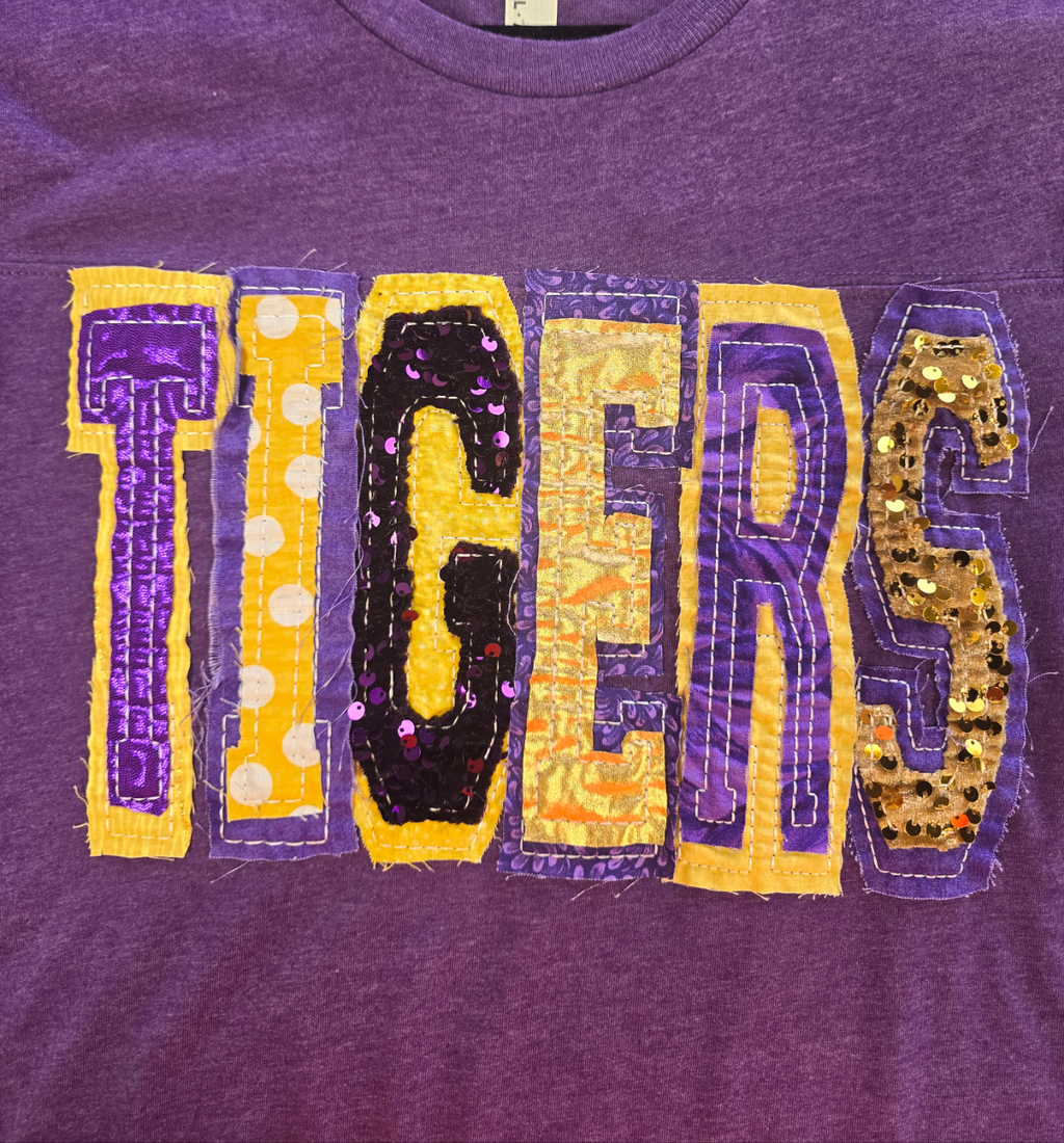 "TIGERS" UNIQUE SEQUIN DOUBLE STACKED LETTERED HEATHERED PURPLE FOOTBALL T-SHIRT | Small - 3X | Charlotte's Classy Closet