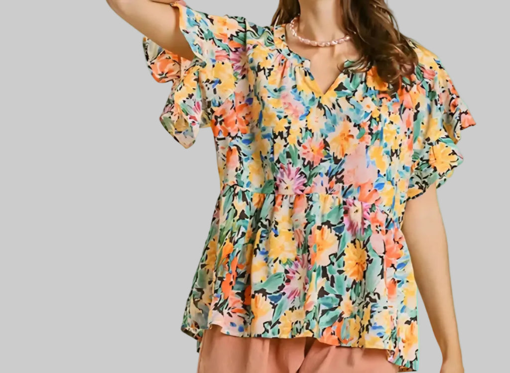 Woman wearing a colorful floral dress against a beige background