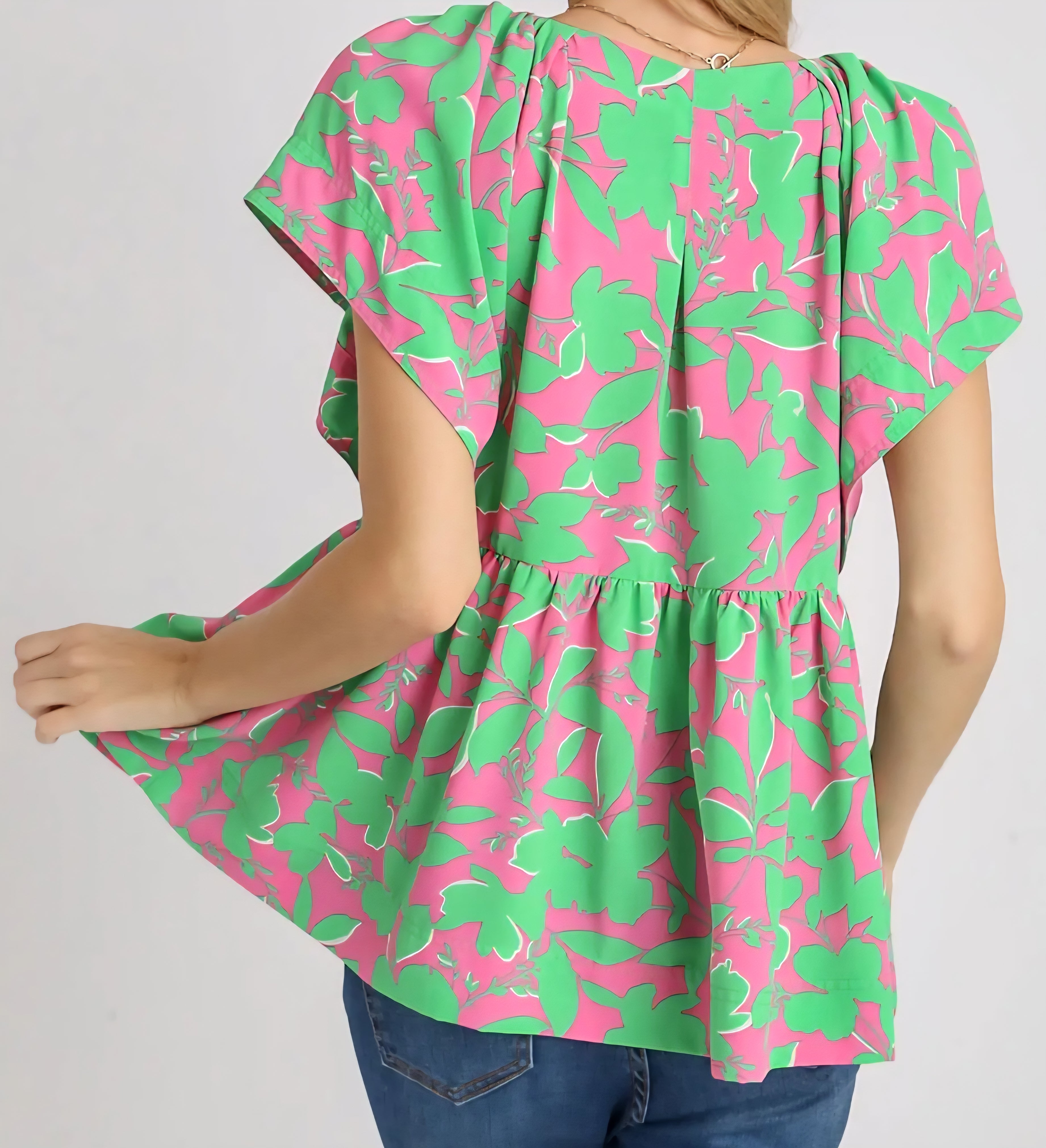 Green and pink floral blouse on a plain background