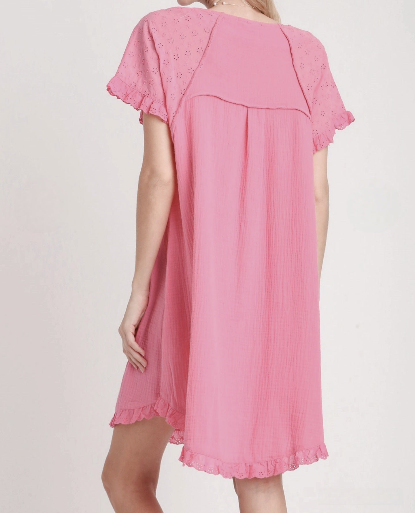 Cotton gauze Pink dress with lace details on a plain background