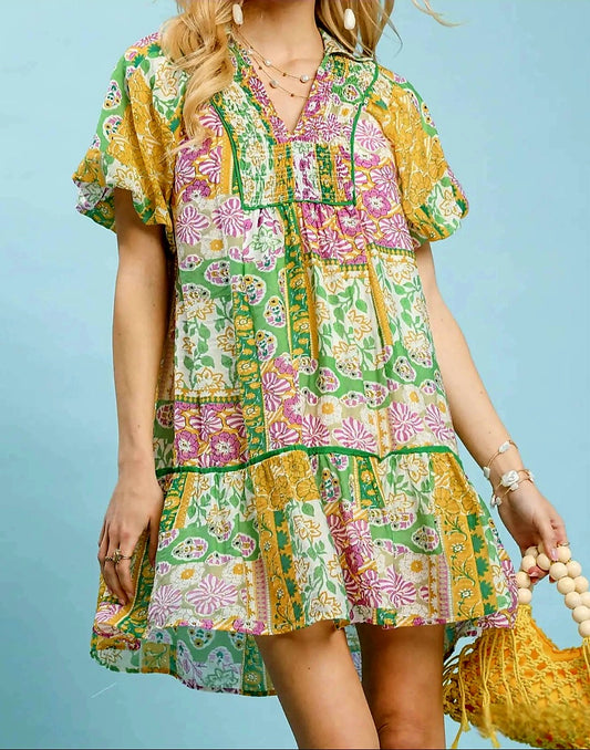 Woman wearing a colorful floral dress against a light blue background