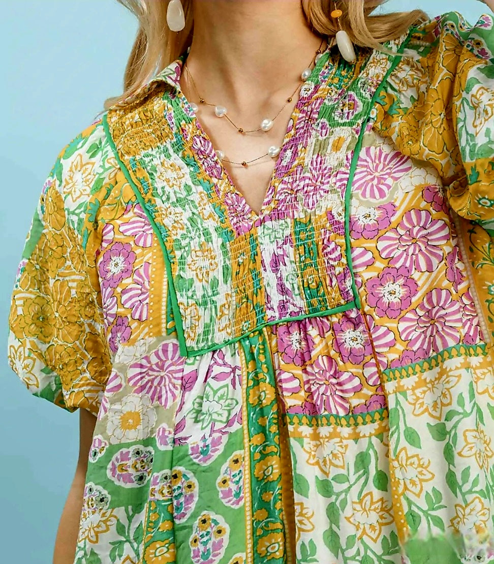 Colorful floral patterned shirt worn by a person against a blue background