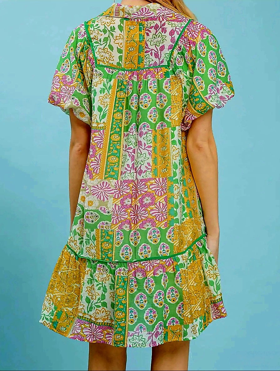 Woman wearing a colorful patterned dress against a blue background