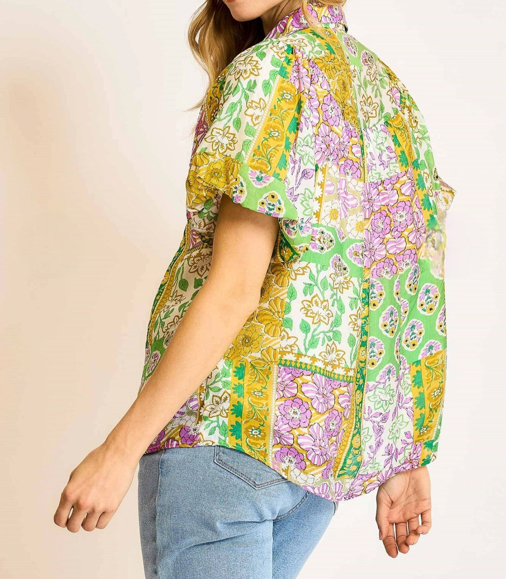Person wearing a colorful patterned shirt with a neutral background