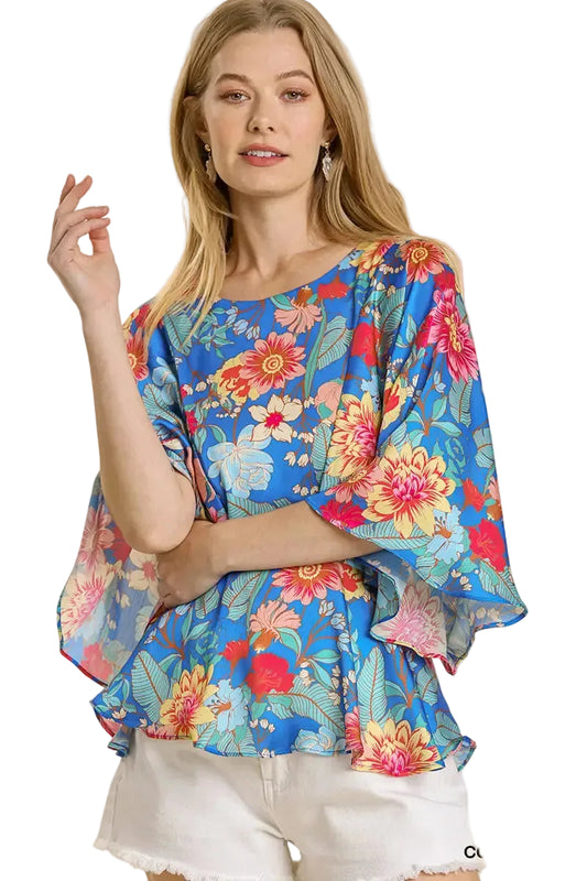 Woman wearing a colorful floral blouse on a beige background